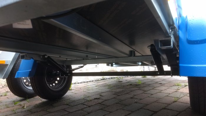 Undervy av ett Fogelsta LO750U släpvagn med nätgrindar och vått underrede.