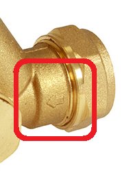 Närbild på ett mässingsventilrör med röd markering kring flödesriktningssymbolen.