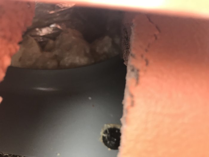 Bild på en takpanna lyft från sitt läge som visar utrymmet under och möjlig dålig spikning.