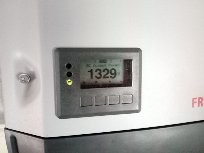 Närbild av en apparatdisplay som visar siffran 1329 W, indikerar att enheten är inkopplad och fungerande.