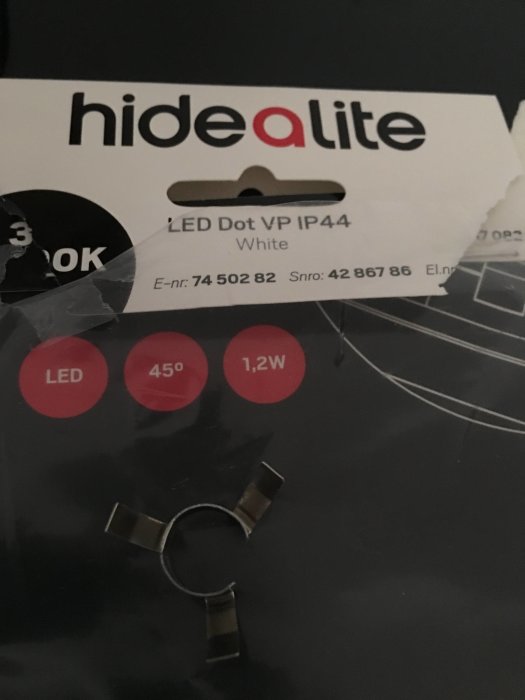 LED-spotlight förpackning med metallclips i förgrunden.