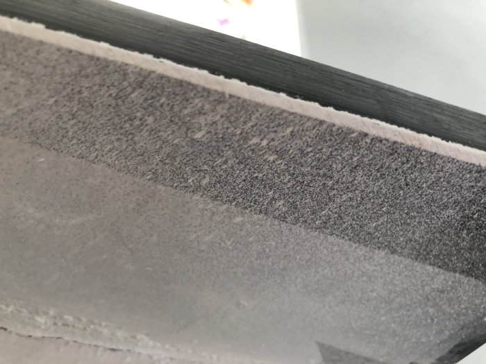 Close-up of a windowsill that appears to be made of fiber cement board, showing its texture and edge detail.