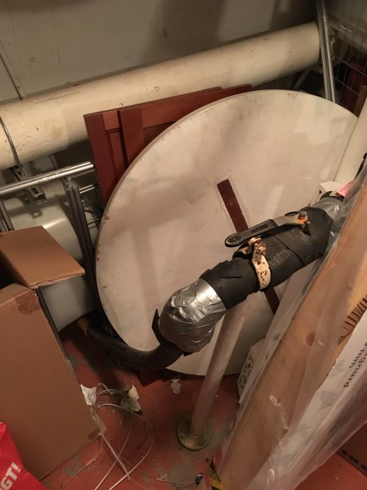 Rörledningar och ventiler i en rörig källare, tänkt för avstängning av vatten.