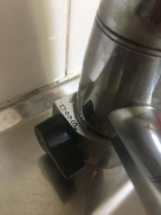 Vattenavstängningsvred för diskmaskin i läge S, vredet verkar slitna vid kanten av diskbänken.