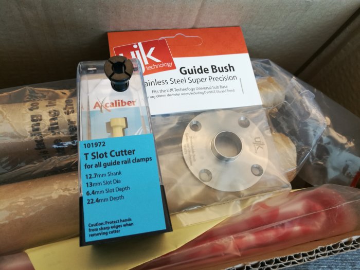 En T-fräs för skentvingar, 1/4" hylsa och en kopierhylsa till router visas i förpackningar.