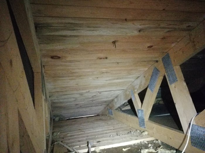 En bild på råspont i takstolarna på en vind, behandlad för mögelskador, med synliga tecken på tidigare dålig ventilation.