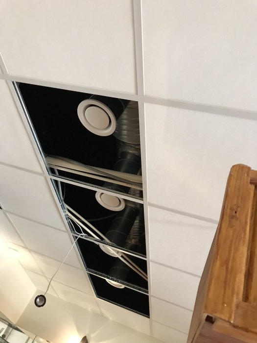 Ventilationskanaler och kablar ovanför öppet undertak i ett byggprojekt.