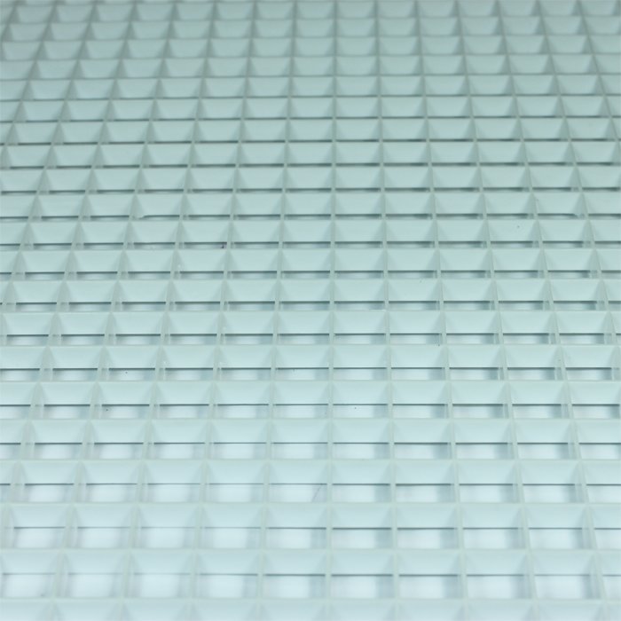 Ventilationsraster i plast med ett mönster av upprepande kubiska hålrum.