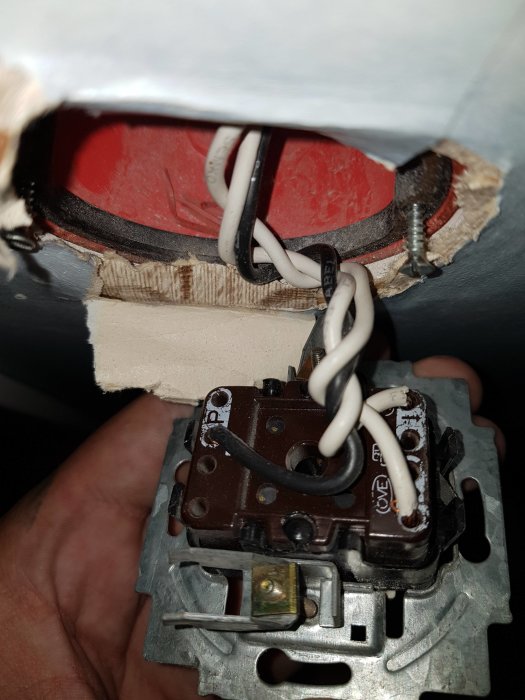 Eluttag utan synlig blå neutraltråd, endast med svart och vit ledning kopplad, i en öppen väggstruktur.