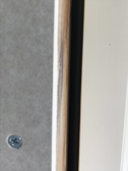 Närbild av demonterad fönstersmyg med synlig gummilist mellan karm och regel vid renovering.