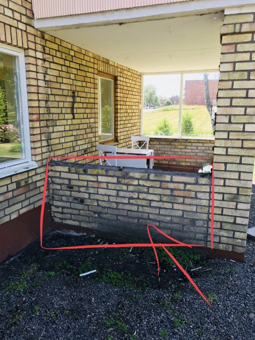 Del av hus med tegelfasad och markerat område för planerat byggprojekt under ett takutsprång.