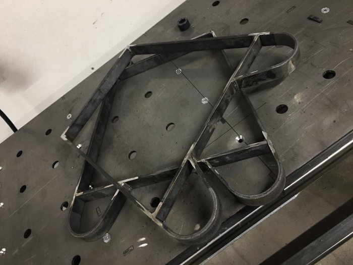 Metallben till ekbänk i geometrisk design på ett arbetsbord.
