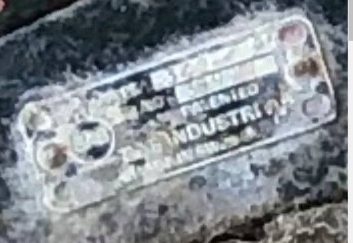 Suddig bild på en försliten metallskylt med texten "patenterat" och "made in sweden".