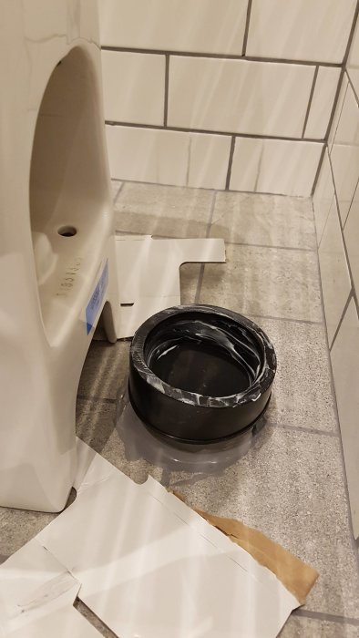 Toalett med ett 110 mm rör och en WC-nippel på ett badrumsgolv.