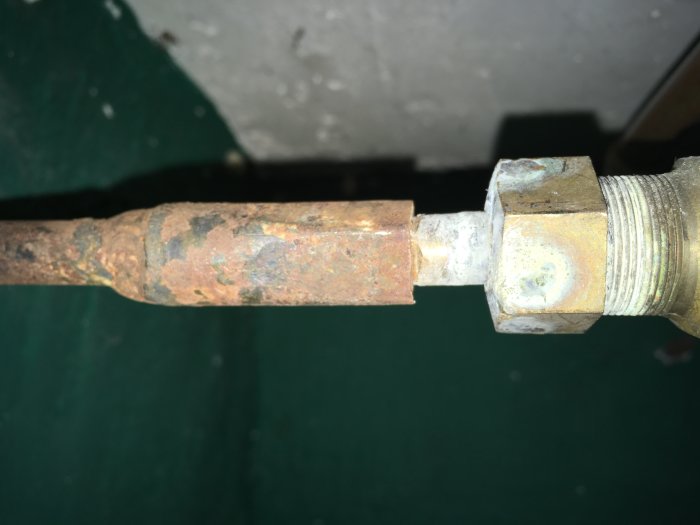 Rostig vridstång kopplad till en ventil, som visar tecken på slitage och korrosion.