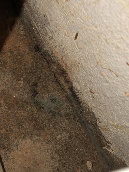 Vattenskada och mögelbildning under bänkskåp i kök efter läckage.
