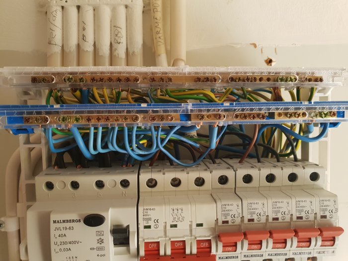 Elektrisk fördelningstavla med märkta nollskensavdelningar och anslutna kablar.