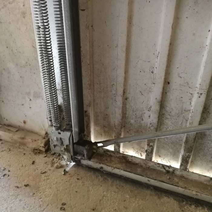Närbild på en garageport nedre del där det inte finns en uppenbar plats för att fästa ett hänglås.