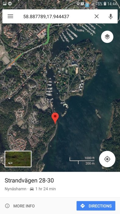 Satellitbild över Strandvägen i Nynäshamn vid havet, markerad med en röd pin på en smartphone-skärm.