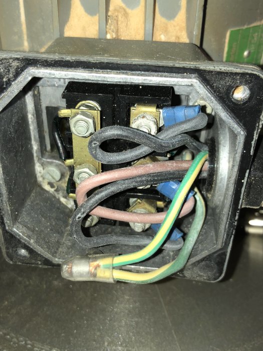 Närbild på öppen eldosa med synliga elektriska kablar och anslutningar, inuti en vägginstallation.