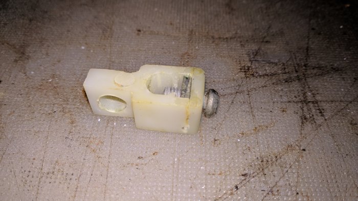 Trasigt plasthus med låsskruv för handfatsproppens öppet/stängd-mekanism.