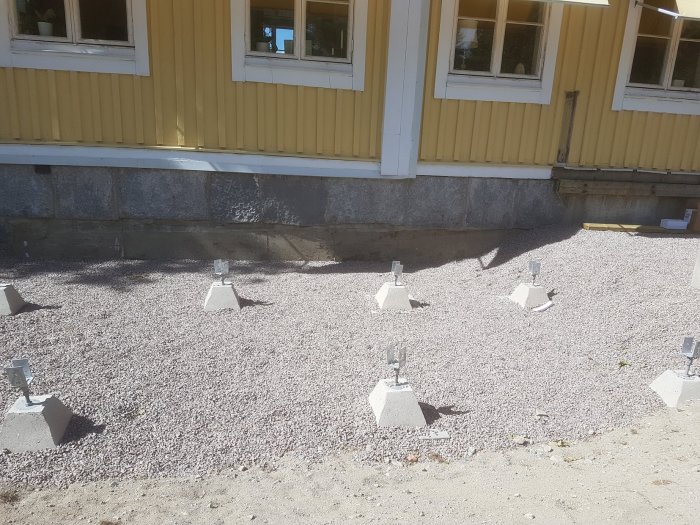 Plintar på betongplattor för husgrund med grus, singel och markisolering synligt.