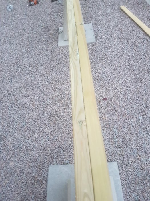 Bärlina av trä lagd på grusunderlag, med synlig struktur, dimension 45x170, klar för installation i byggprojekt.