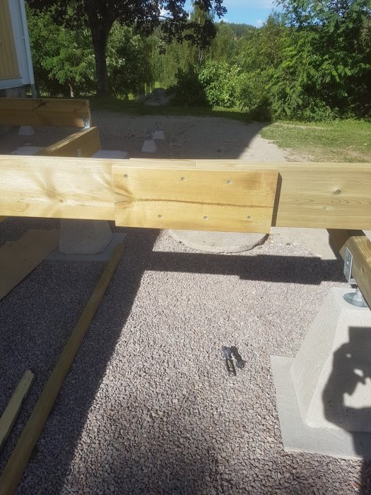 Skarvning av reglar med spillvirkesbitar för förstärkning i ett pågående byggprojekt utomhus.