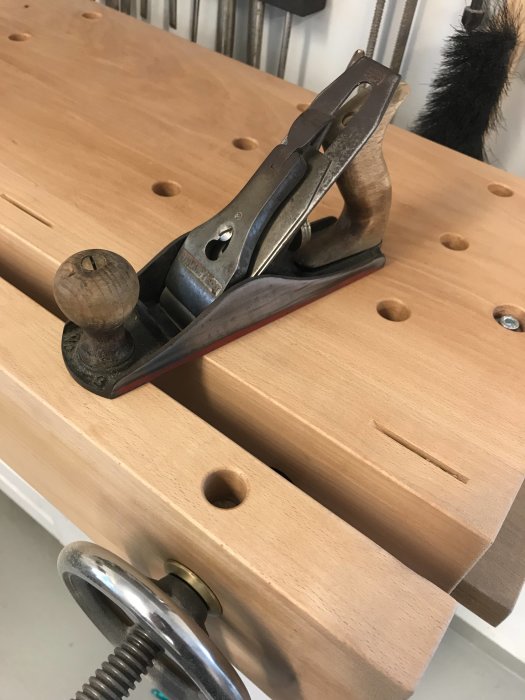 En hyvel på en arbetsbänk med trädominon och borrade hål, presenterad som ett nytt verktyg.