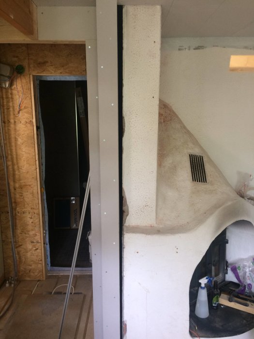 Glipa mellan en murstock och väggen i ett pågående byggprojekt inomhus.