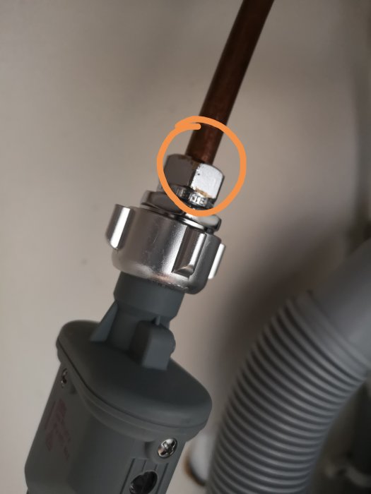 Anslutningen av en 6-kantssnippel till en vattenledning med tecken på vattenläckage markerat med en cirkel.