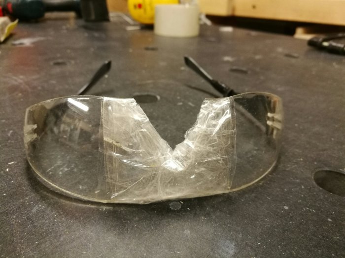 Skyddsglasögon med utskärning för näsan på arbetsbänk.