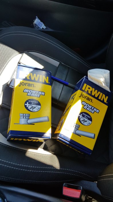 Två förpackningar av IRWIN Joran murbruksharv startkit på bilens säte.