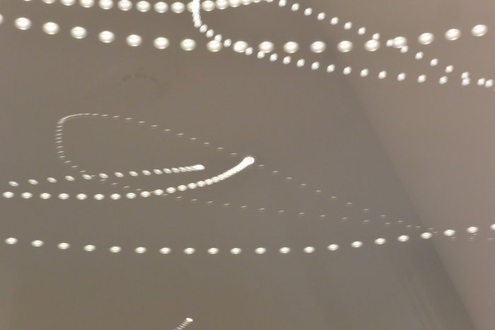 Lång exponeringsbild av LED-spotlights på tak som visar ljusets intermittent natur vid dimning.