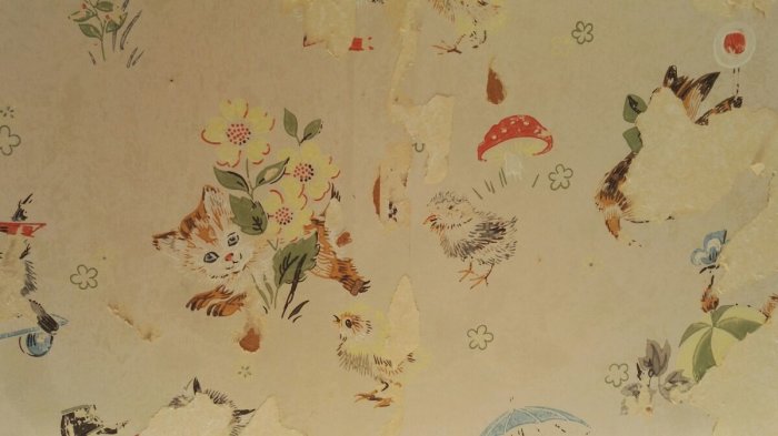 Gammal barn-tapet från 1966 med avskalade partier, visar tecknade djur och blommor.