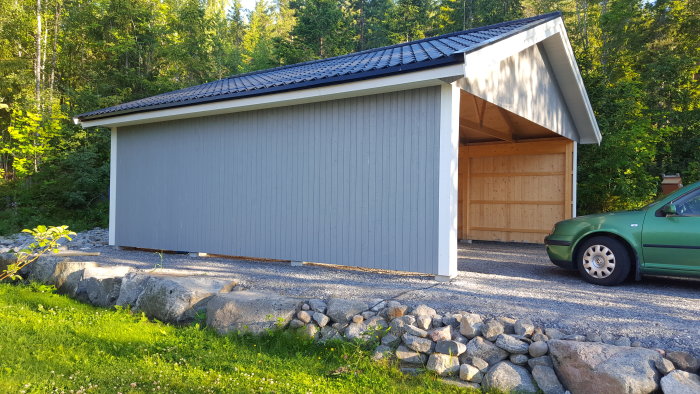 Nybyggd utvändigt färdig carport med takfot och knutbrädor, nära skog.