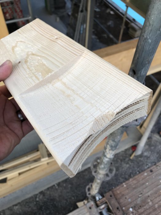 Närbild på en provbit av trä med urskålad del för montering av vinkeljärn i byggprojekt.