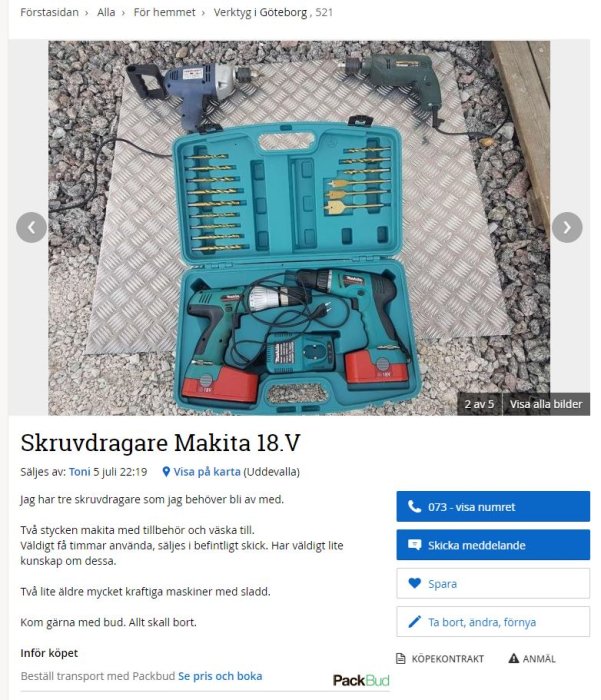 Öppen verktygslåda med två Makita skruvdragare, laddare, batterier och borrset på grusunderlag.