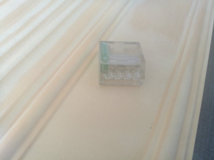 Transparent sockerbitkopplingsklämma på en ljus träyta.