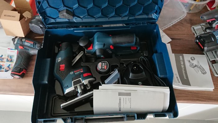 Bosch verktyg i en L-boxx med GKF12V fräs, GHO 12V hyvel, batterier, laddare och manualer.