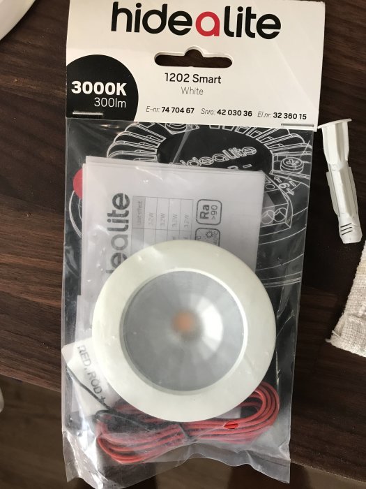 Hide-a-lite 1202 Smart spotlight i förpackning, 3000K 300lm, på ett bord.