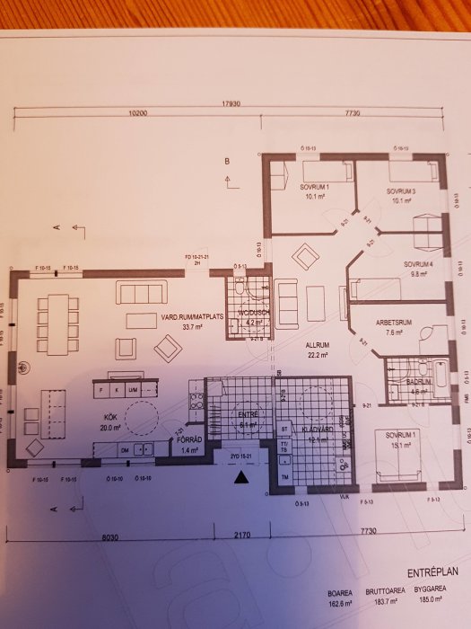 Ritning av en husplan med markerad köksö, sovrum, badrum och entré för ett pågående byggprojekt.