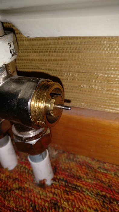 Närbild av trög rörlig ventilpiggen på en radiator med synlig smörjning och verktygsspår.