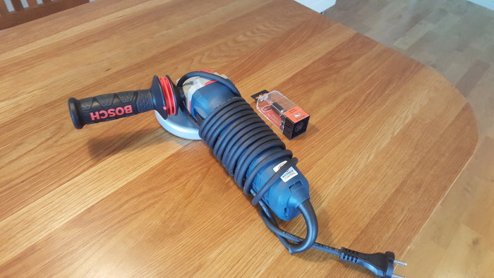 Ny vinkelslip och ett kopierstål förpackning på ett träbord, som illustrerar en händig användares senaste verktygsköp.