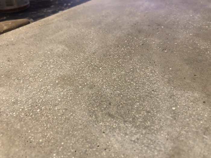 Betonplatta med vita Husfix-rester som inte blivit grått efter torkning.