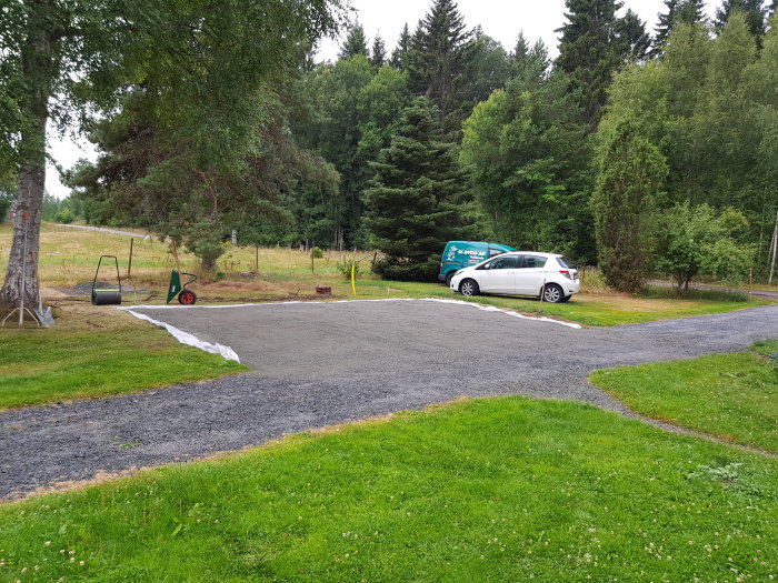 Nygrusad bilparkering på 40 kvadratmeter med en vit bil parkerad och skottkärra i förgrunden.