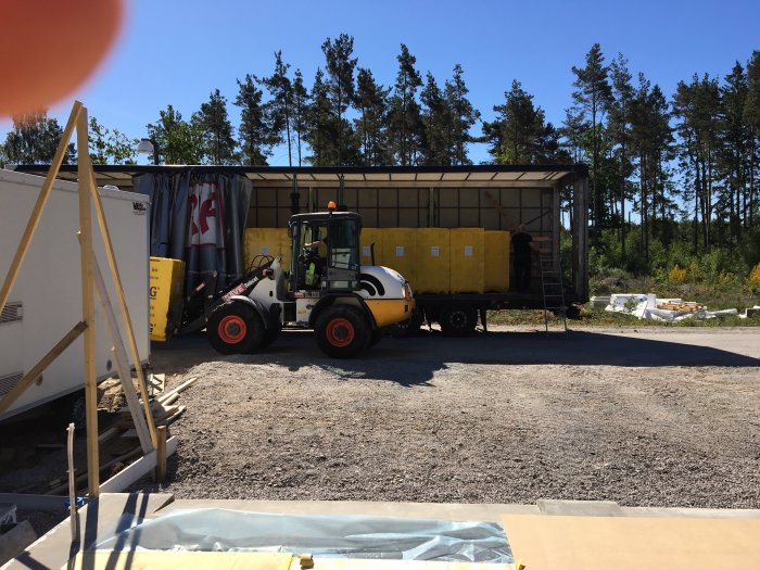 Gaffeltruck lastar gula Xella Ytong lättbetongblock vid byggarbetsplats.