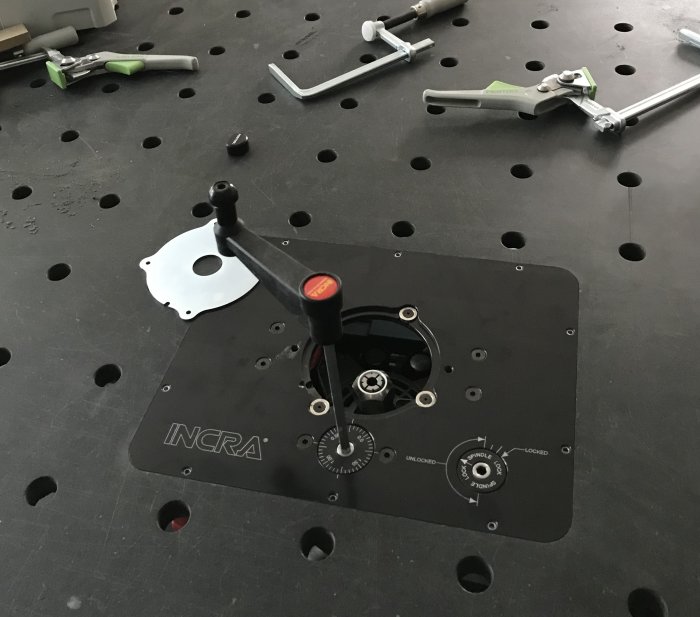 Jessem router lift justerad för precision på en INCRA-bordplatta med magnetiska insertdelar och verktyg omkring.