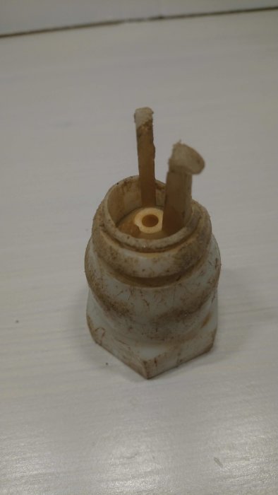 Smutsig, vit plastventil med en bruten spak och inre gängning, storlek cirka 32-33mm, placerad på ett vitt underlag.