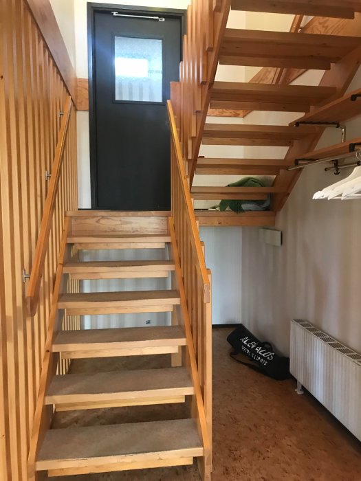 Trappa i suterränghus med heltäckningsmatta och förvaring under, inför renovering.